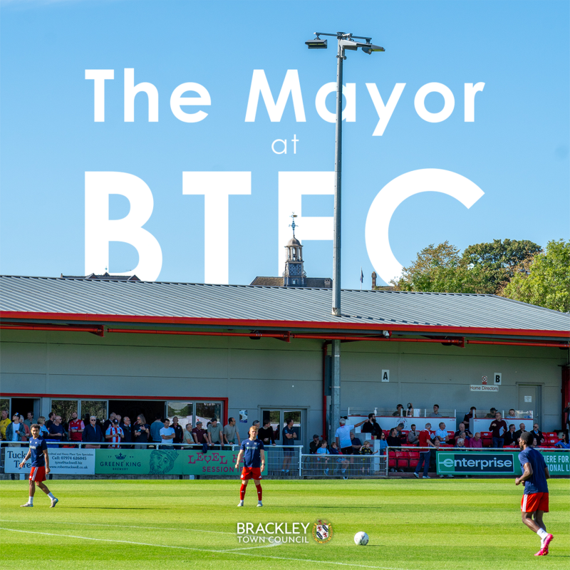 Photo of Brackley Town Football Club pitch, with white text that reads 'The Mayor at BTFC' and Brackley Town Council logo at the bottom.