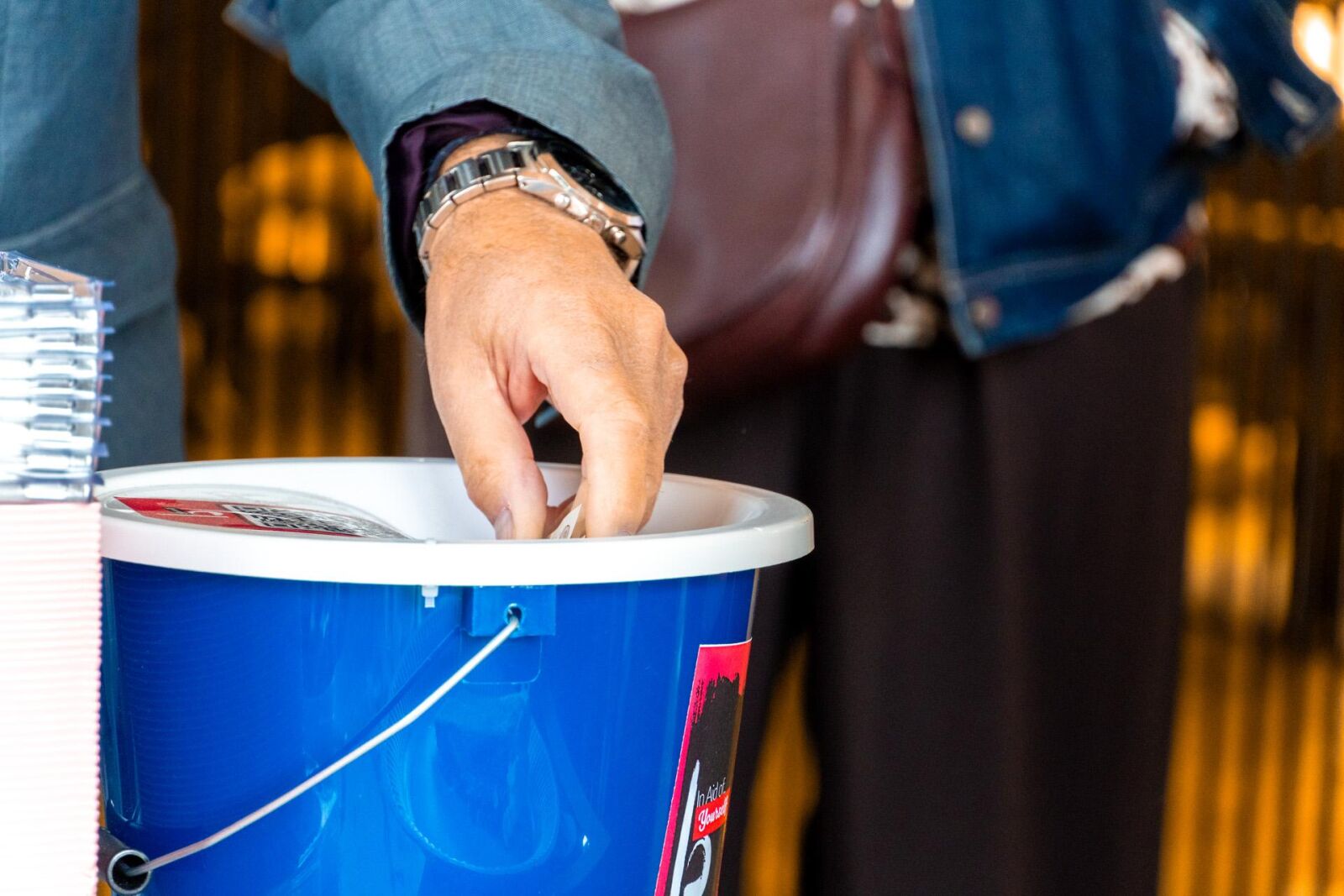A hand donating to the bucket